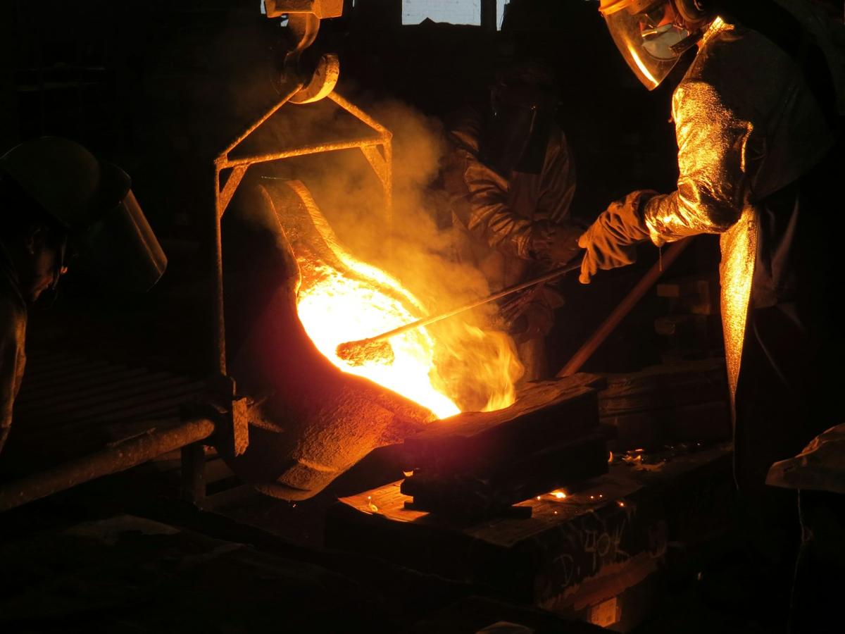 Foundry worker handling hot metal